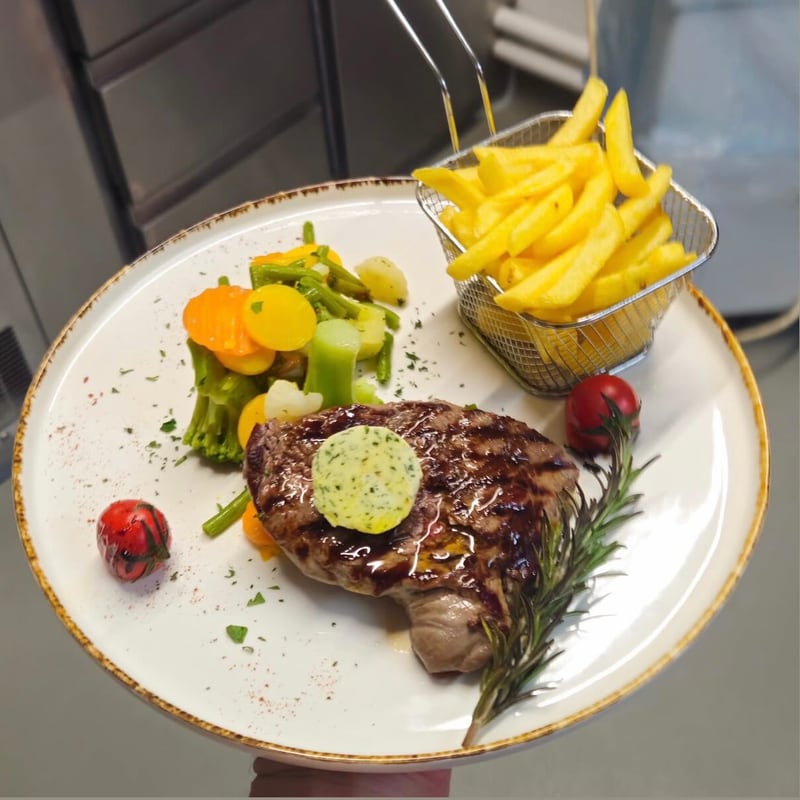 Steak vom Grill mit Kräuterbutter, Pommes und Gemüse